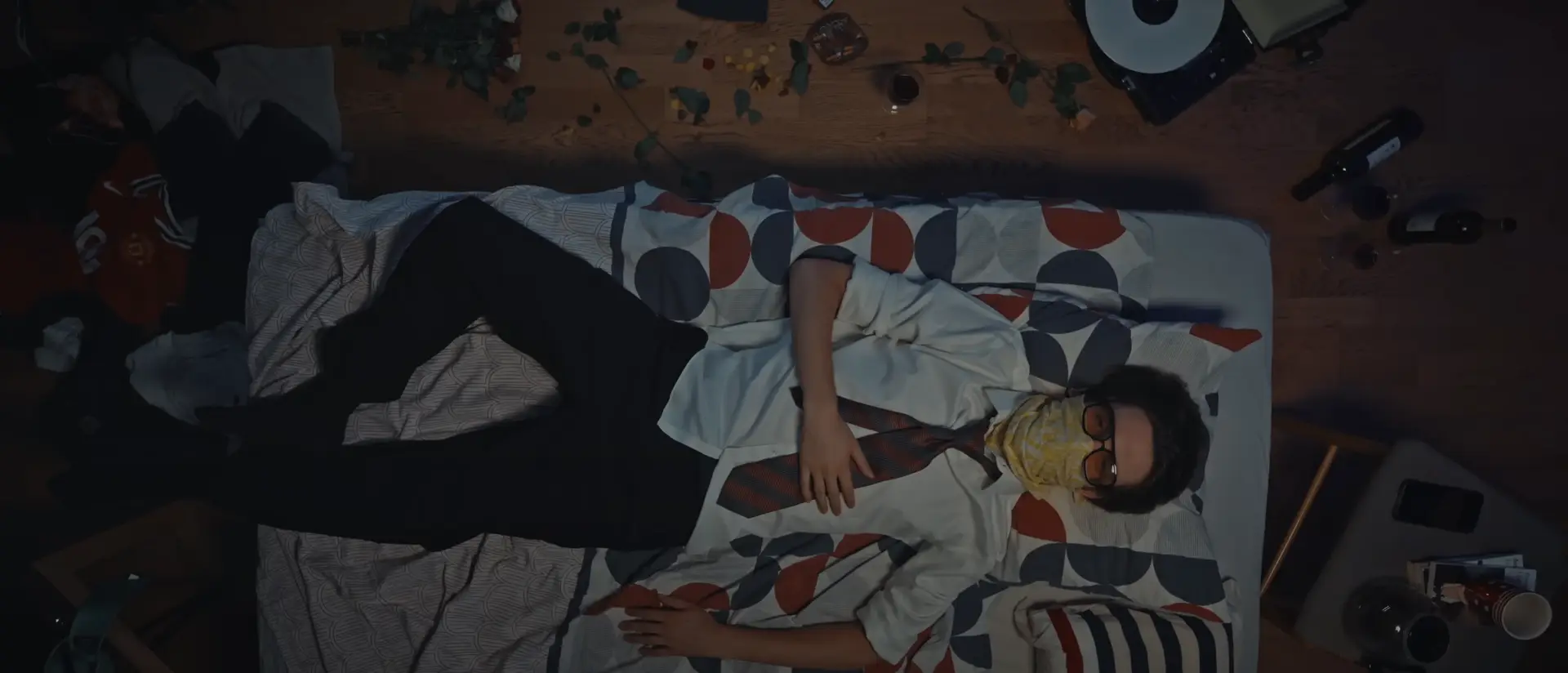 jeune rappeur, allongé sur son lit en top shoot on le sent rêveur et nostalgique autour c'est le bazar comme si c'était une fin de soirée