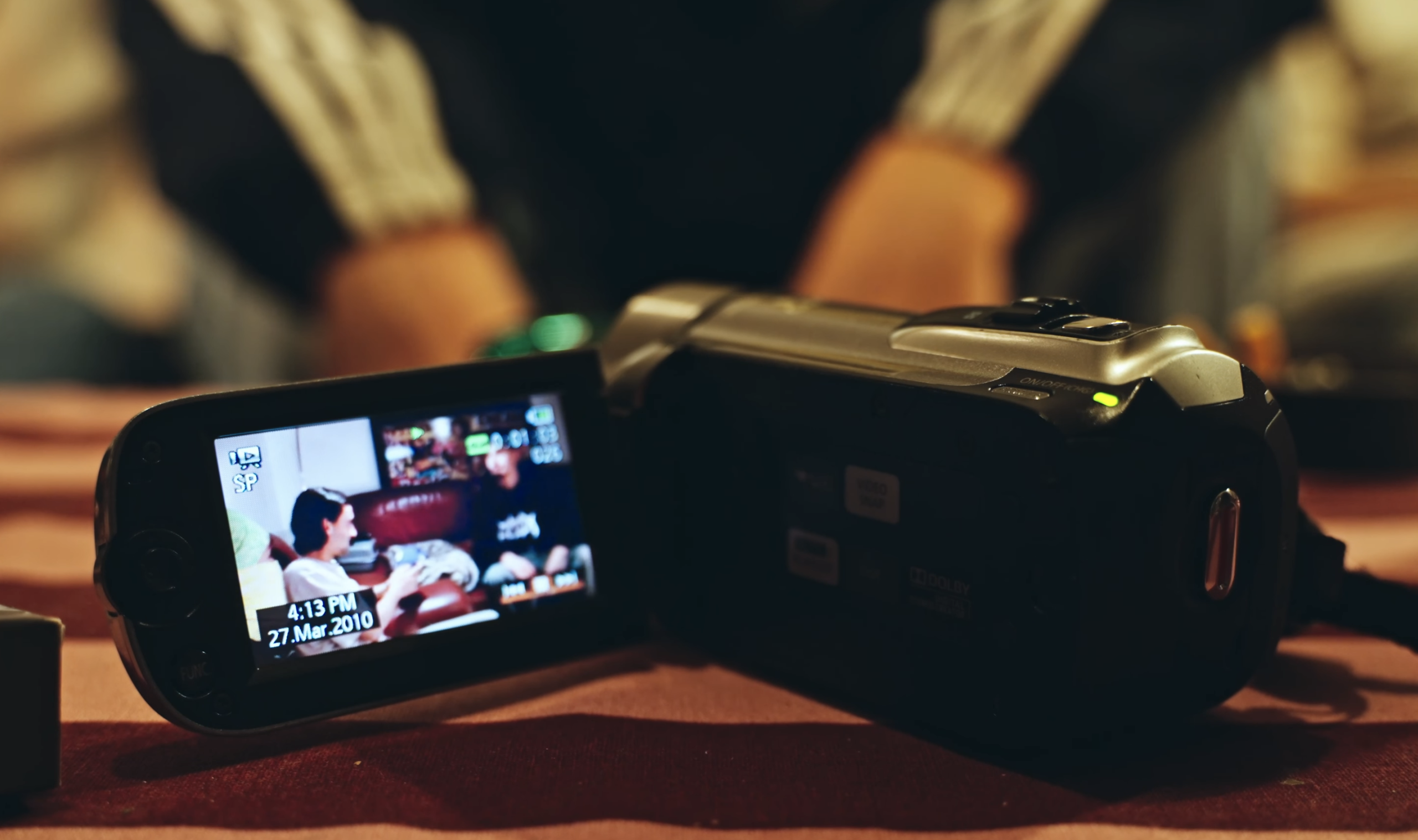 caméscope sur une table, on voit une soirée entre potes, ambiance c'est un caméscope assez âgé, on comprends que la caméra immortalise l'ambiance