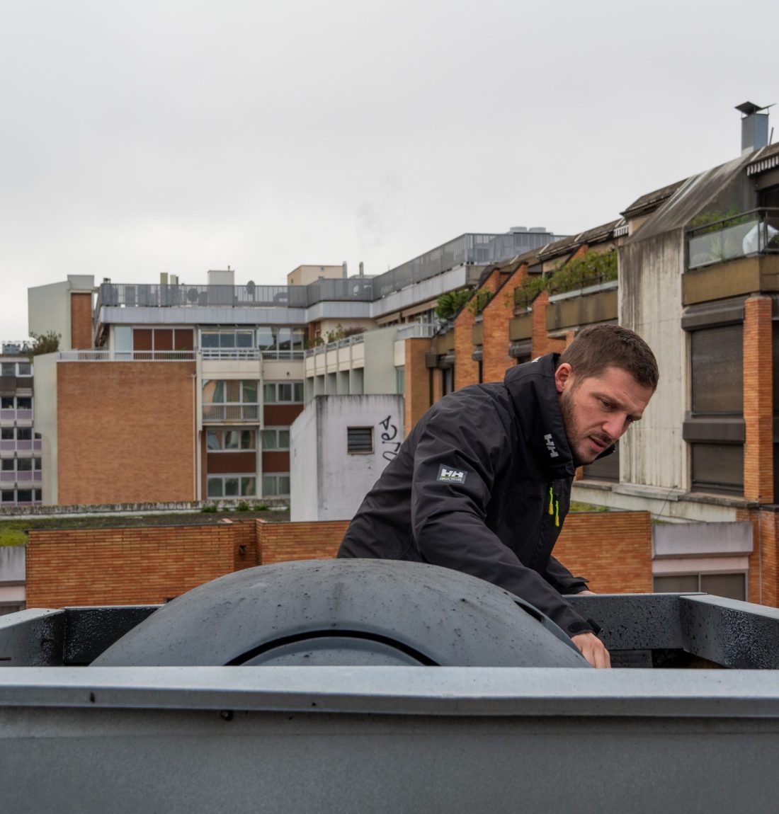 Ludovic de LP Ventil est entrain d'expertiser une sortie de ventilation sur le toit d'un restaurant de Toulouse-centre. On voit les bâtiments toulousain marqué par leurs briques rouges en arrière-plan.