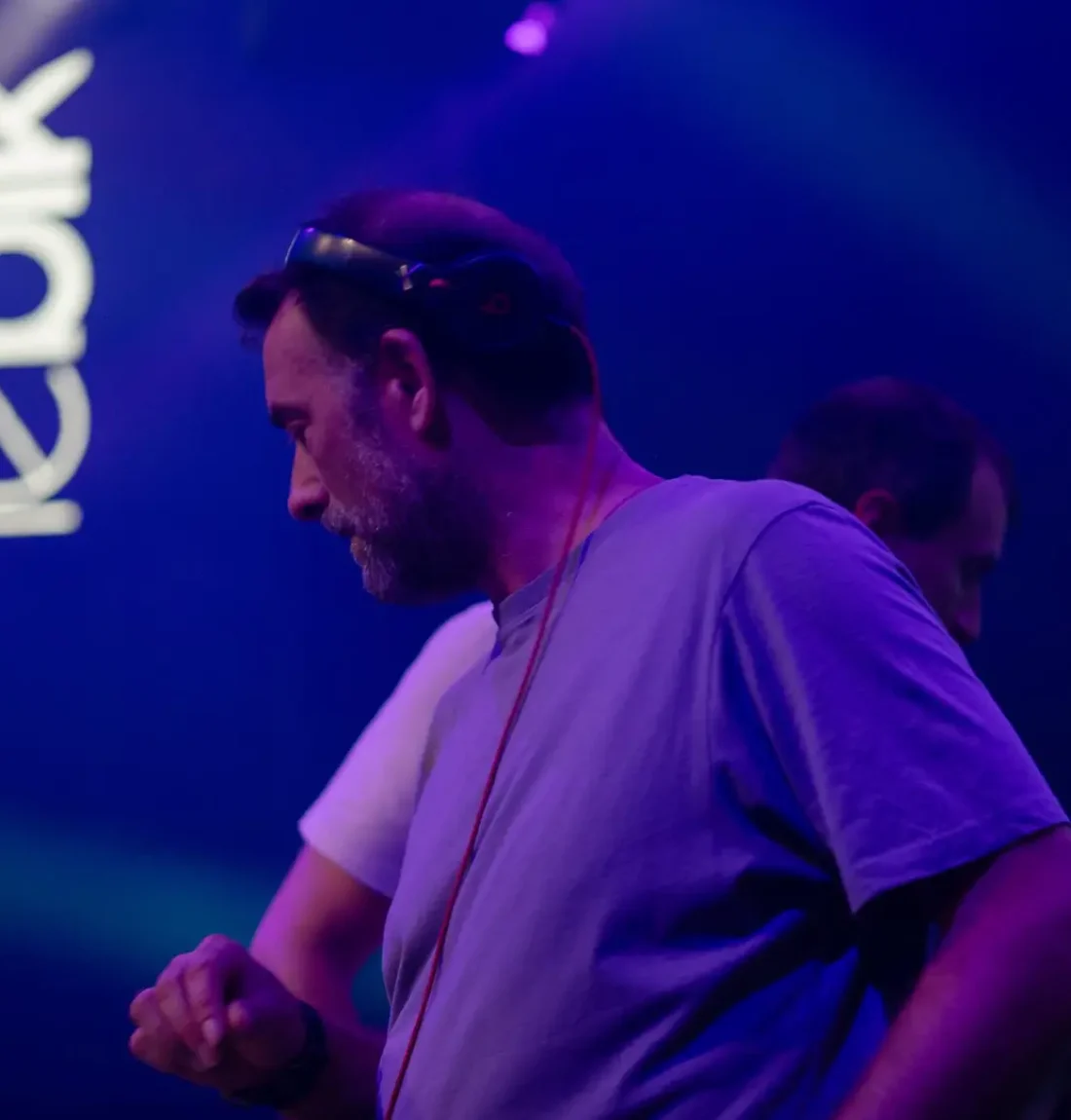Les deux membres du groupe the deep brothers sont de profil chacun dans un sens celui au premier plan est axé vers la gauche de l'image avec un casque beats sur la tête. Le logo Bikini en arrière plan est visible.