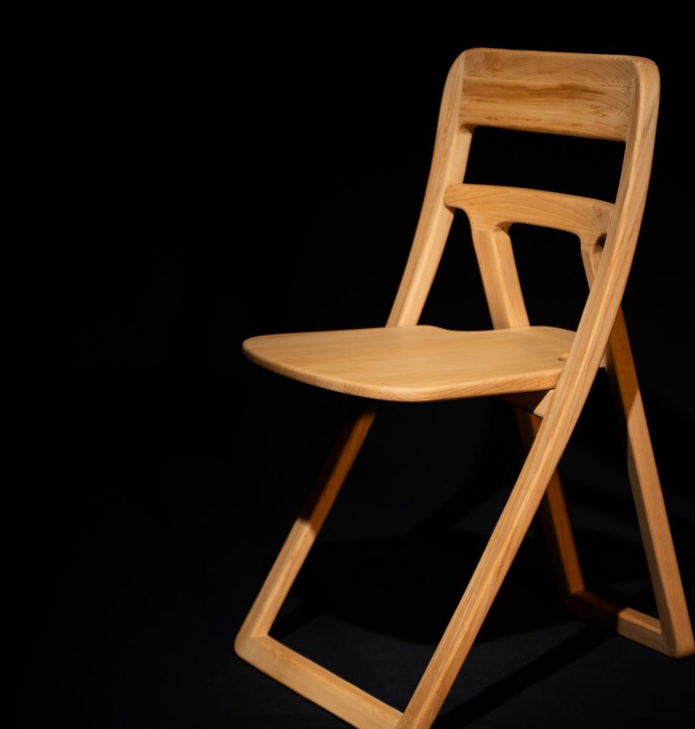 Photo de chaise de profil, format horizontal, chaise qui contraste, jaune avec le fond noir