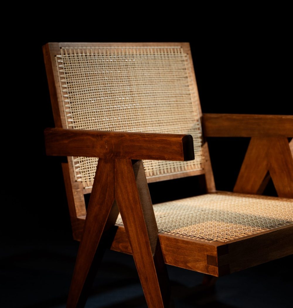 Chaise de créateur en bois exotique sombre, cannage clair, ce qui crée un contraste et valorise le design de la chaise. Photo sur fond noir